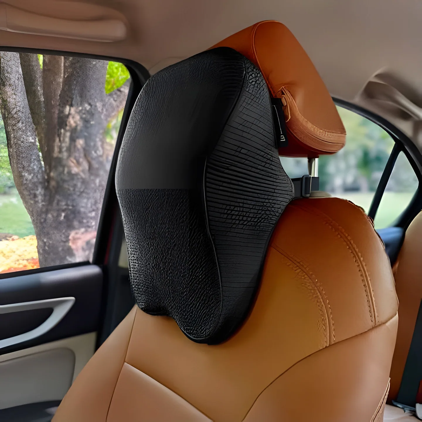 Black memory-foam neck cushion strapped to a car headrest