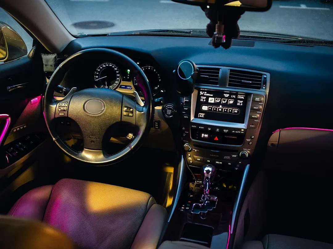 A car cabin at night with ambient light strips along the dashboard and doors