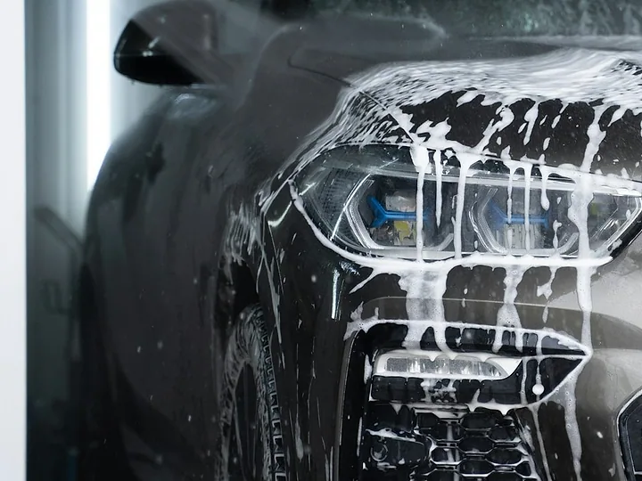 A grey car covered in pre-wash snow foam